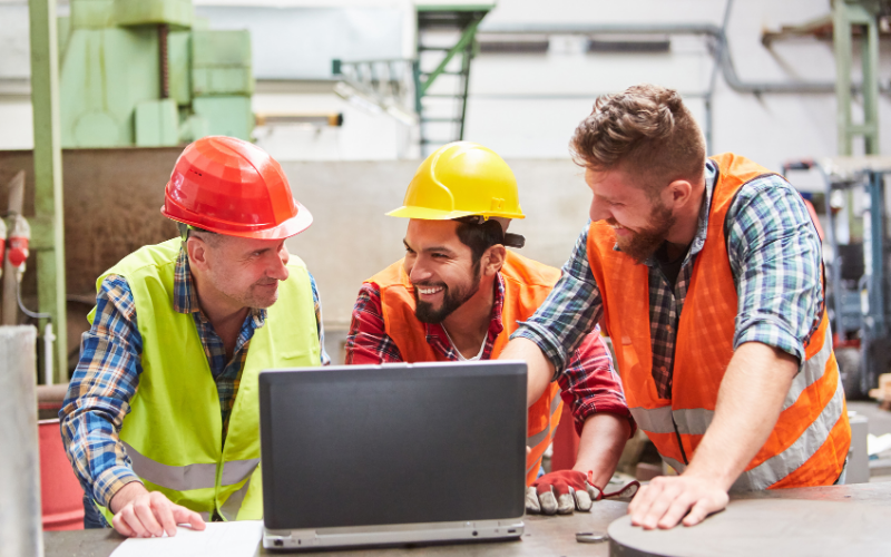 Artisans du bâtiment utilisant un ordinateur pour illustrer la création de site Internet professionnel pour artisans du BTP.