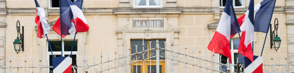 Façade de mairie française avec drapeaux tricolores